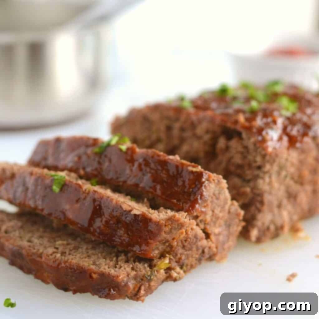 37-Day Meal Blueprint 4 A perfectly sliced classic meatloaf, showcasing its moist, flavorful interior and a glistening, delicious glaze, beautifully presented on a pristine white plate.