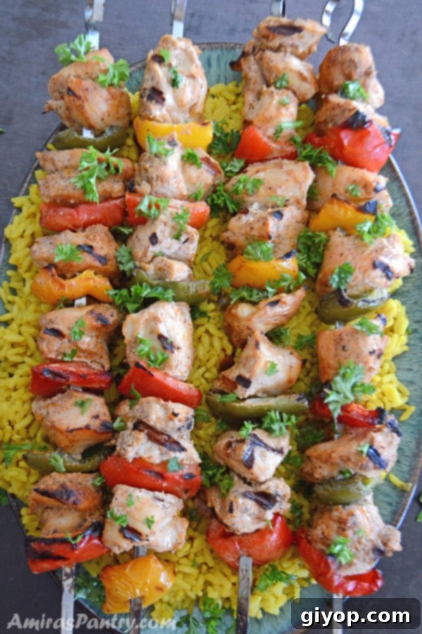 37-Day Meal Blueprint 6 An appetizing infograph showcasing vibrant Middle Eastern chicken kabob skewers, perfectly grilled with colorful bell peppers and onions, elegantly served on a plate.