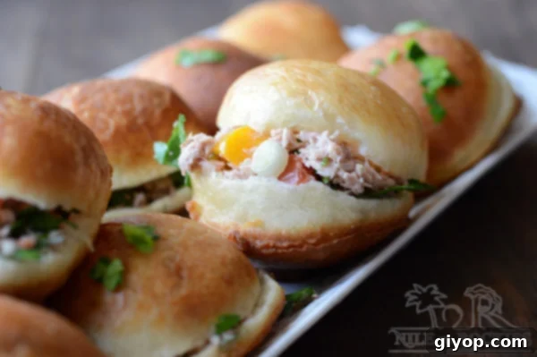 Fried buns stuffed with tuna placed on a serving plate.