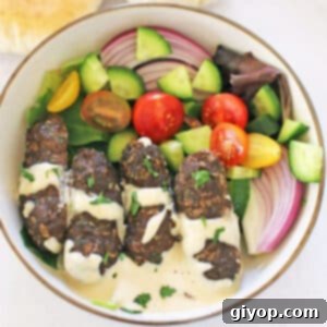A bird's eye view of a plate with kafta, tahini sauce and green salad.