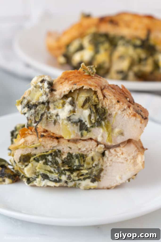 40 Healthy Meal Ideas 4 A close-up view of a perfectly cooked keto stuffed chicken breast, sliced in half to reveal a creamy filling of spinach, cheeses, and artichokes.