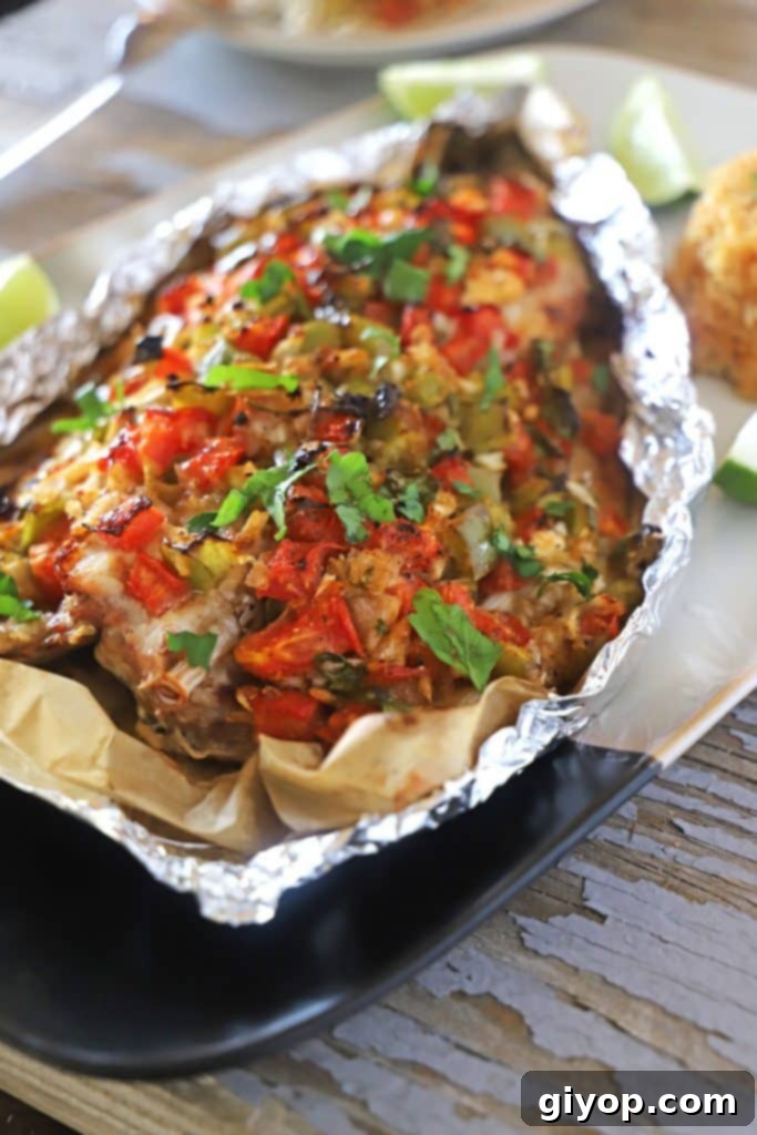 A perfectly baked whole Sea Bass, still wrapped in aluminum foil to preserve its moisture and flavor, ready to be served.