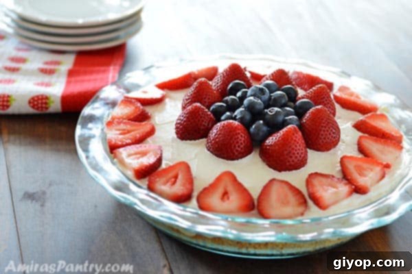 A close-up view of the creamy berry filling and crunchy Golden Oreo crust of a chilled dessert, showcasing the layers and fresh fruit.