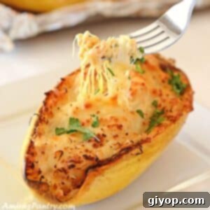 A fork taking strands of the spaghetti squash placed on a white plate.