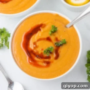 A top view of a white bowl filled with Turkish red lentil soup.