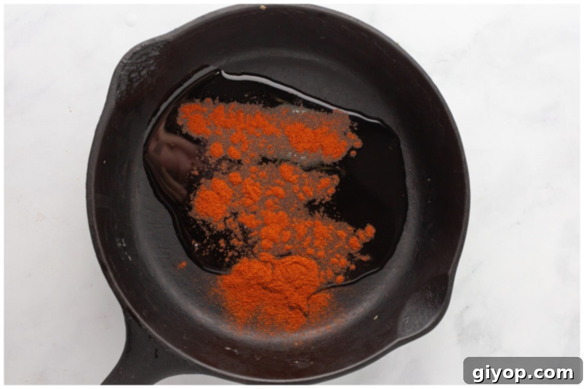A skillet with paprika and oil.