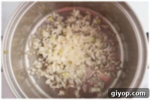 Chopped onions sautéing in olive oil in a pot, turning translucent and fragrant.