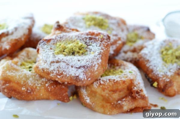 A close up of a single piece of Nabulsi Tamriyeh, cut open to reveal the semolina pudding filling, sprinkled with sugar.