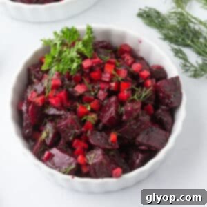 A white bowl of beet and carrot salad, beautifully arranged.