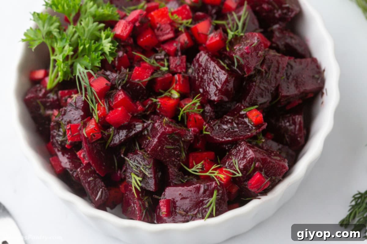 A small white serving bowl filled with a delightful beet and carrot salad, ready to be enjoyed.