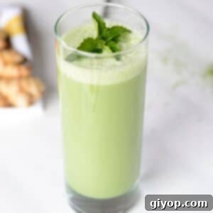 Mint matcha smoothie in a tall glass garnished with fresh mint leaves.