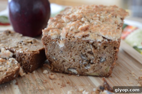 Cozy Apple Cinnamon Crumb Bread 4 A whole apple bread loaf on a wooden cutting board