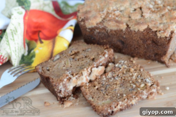 Cozy Apple Cinnamon Crumb Bread 5 A slice of apple bread on a wooden board ready to be served