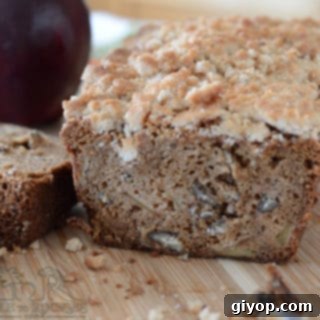 Cozy Apple Cinnamon Crumb Bread 7 A piece of bread on a wooden board