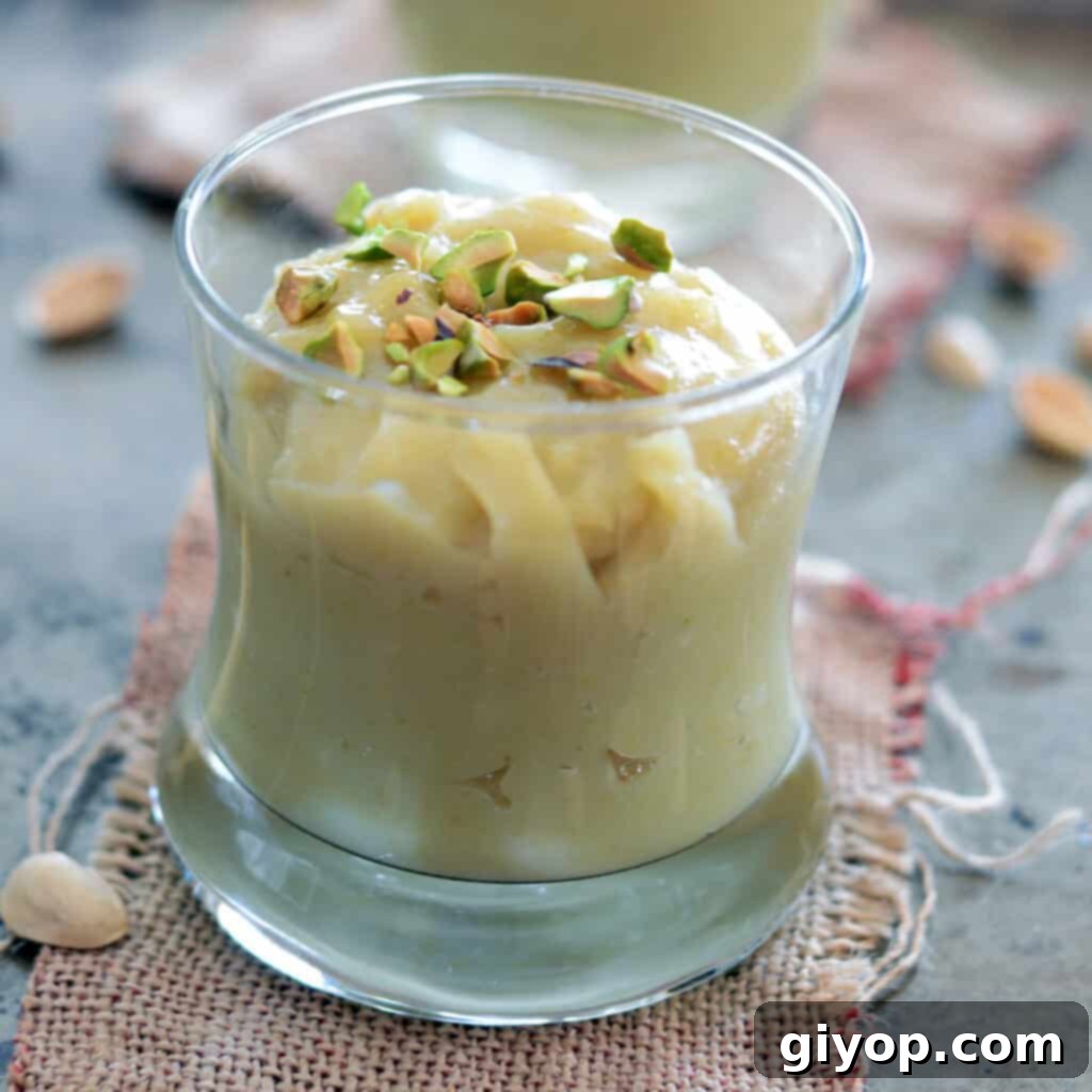 Meal Plan 7 A clear glass cup filled with fresh, homemade pistachio pudding, elegantly garnished with finely chopped pistachios.