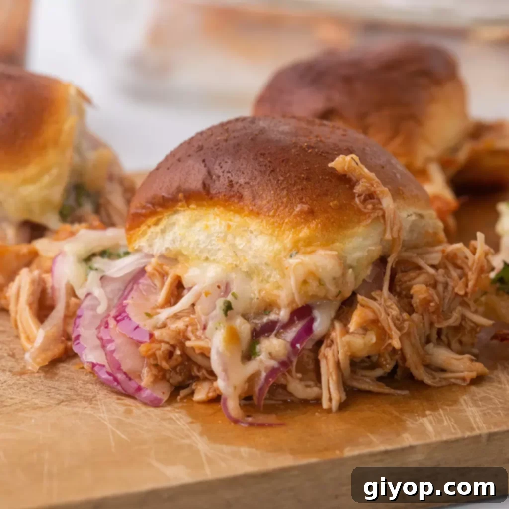 A close-up shot of a savory BBQ chicken slider, garnished with fresh toppings, resting on a wooden cutting board.
