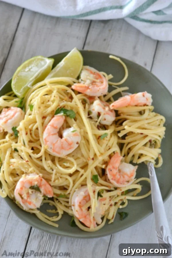 A dish is filled with food, with Shrimp Scampi and Pasta, garnished and ready to serve.