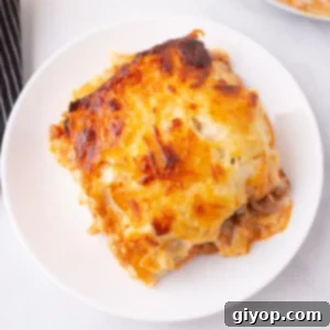 A delectable slice of Lasagna without Ricotta, showcasing its perfectly cooked noodles, rich meat sauce, and creamy béchamel layers, topped with melted golden cheese.