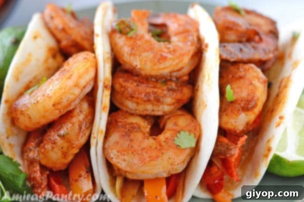 Shrimp fajitas served in warm tortillas, garnished with fresh cilantro and lime wedges.