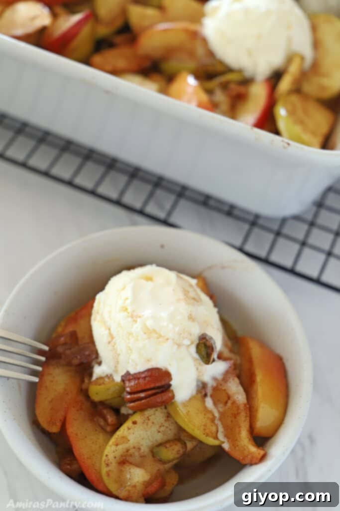 Meal Plan 72 7 A small, inviting serving bowl filled with healthy baked apple slices, generously topped with a scoop of vanilla ice cream, capturing the essence of a warm and comforting dessert.