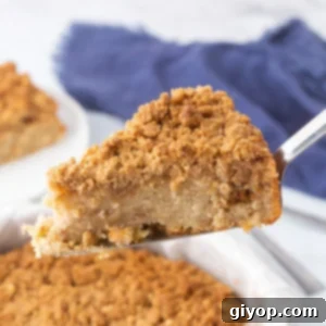 Golden Apple Cinnamon Streusel Cake 2 A slice of apple crumb cake being served, showing its delicious layers.