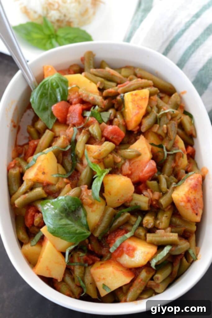 Meal Plan 6 An inviting overhead view of a white serving dish filled with a rich, savory green beans and potatoes casserole, glistening with sauce.