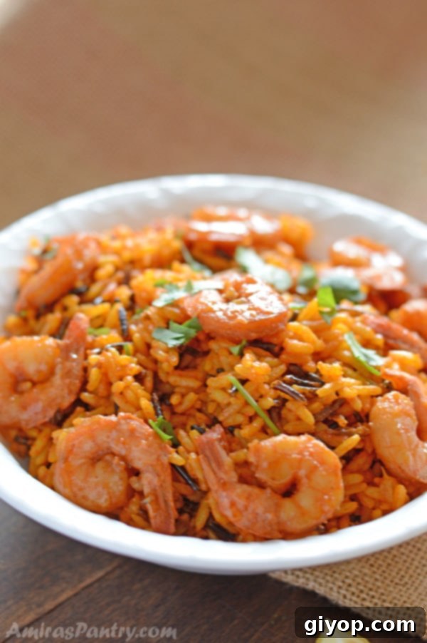 A white bowl showcasing a vibrant dish of spicy shrimp served over a bed of wild rice.