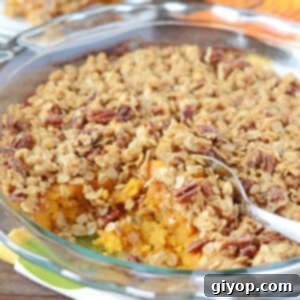 Sweet Golden Butternut Bake 6 A rounded glass dish with butternut squash placed on a wooden table.