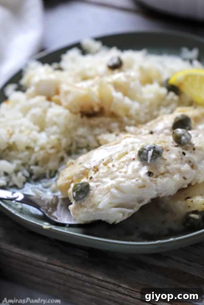 Master Your Meals 4 A vibrant green plate showcasing a perfectly baked cod fillet, glistening with lemon garlic cream sauce, served alongside a fluffy mound of white rice for a complete and healthy meal.