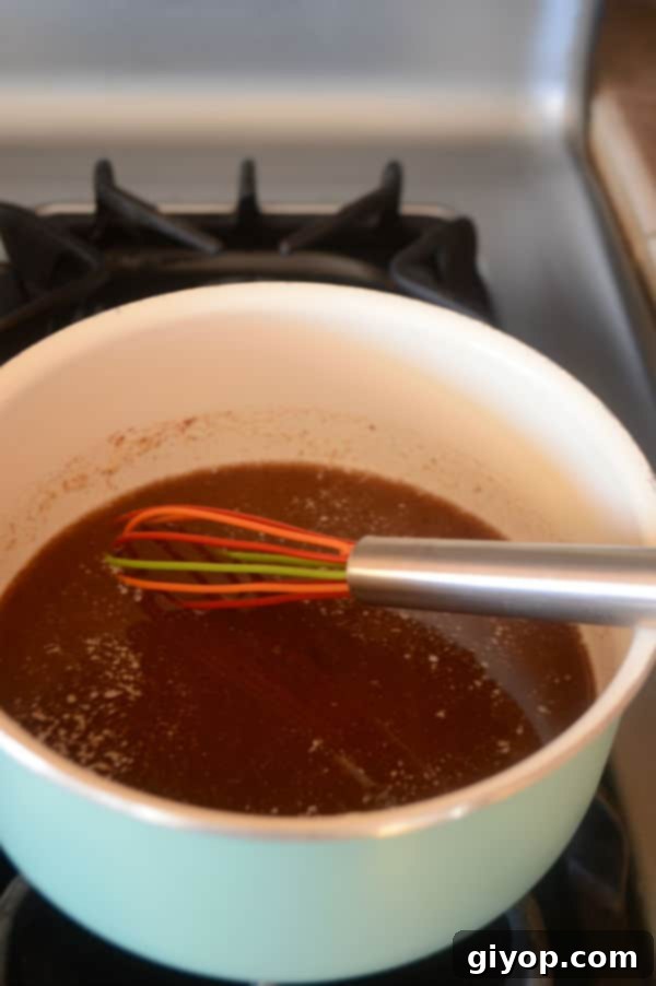 A bowl of rich caramel sauce next to a whipping spoon, ready for pouring