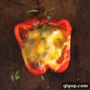 Taco Bell Pepper Boats 2 Stuffed bell pepper on a baking sheet topped with melted cheese.