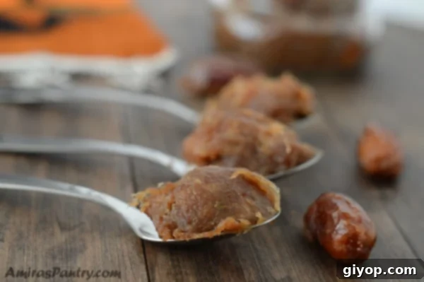 A close up of homemade date paste, Agwa, on a wooden cutting board with traditional spoons