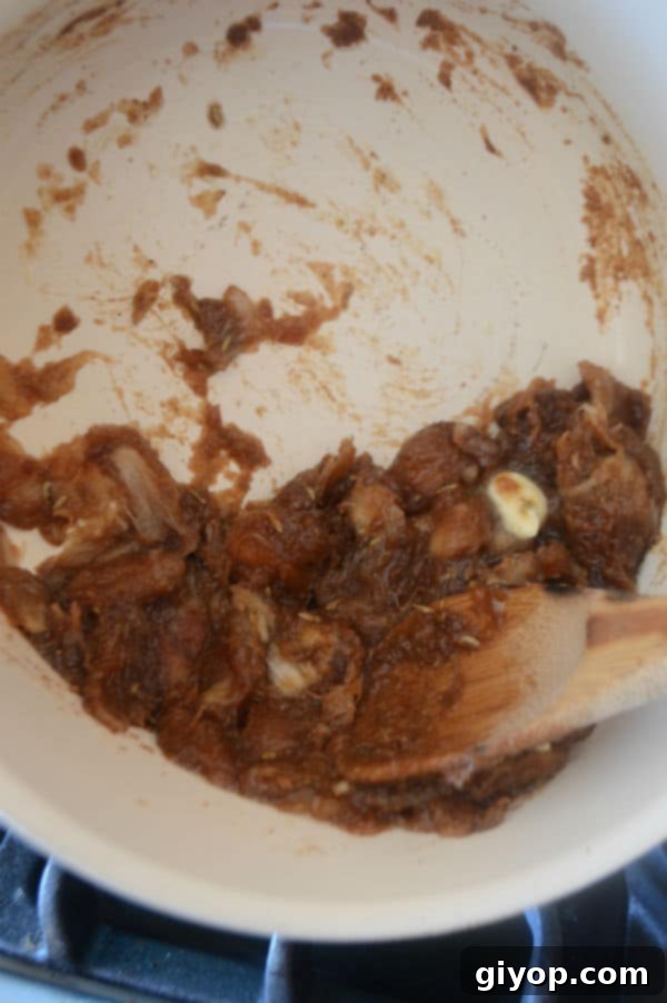 A close up of date paste in a bowl with a spoon, ready for culinary use