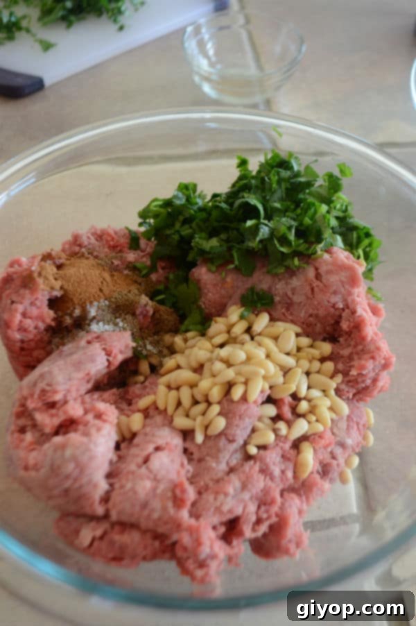 A bowl of ground beef mixture on a table, prepared for making meatballs.