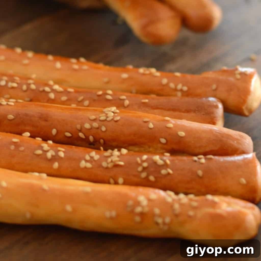 Crispy Sesame Breadsticks 2 Crispy Egyptian breadsticks (Bo'somat) lined on a rustic wooden table, ready for snacking.