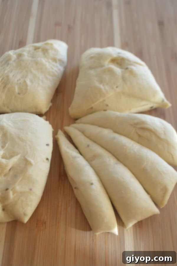 Crispy Sesame Breadsticks 5 A wooden cutting board, with evenly divided dough pieces sitting on top, ready for shaping.