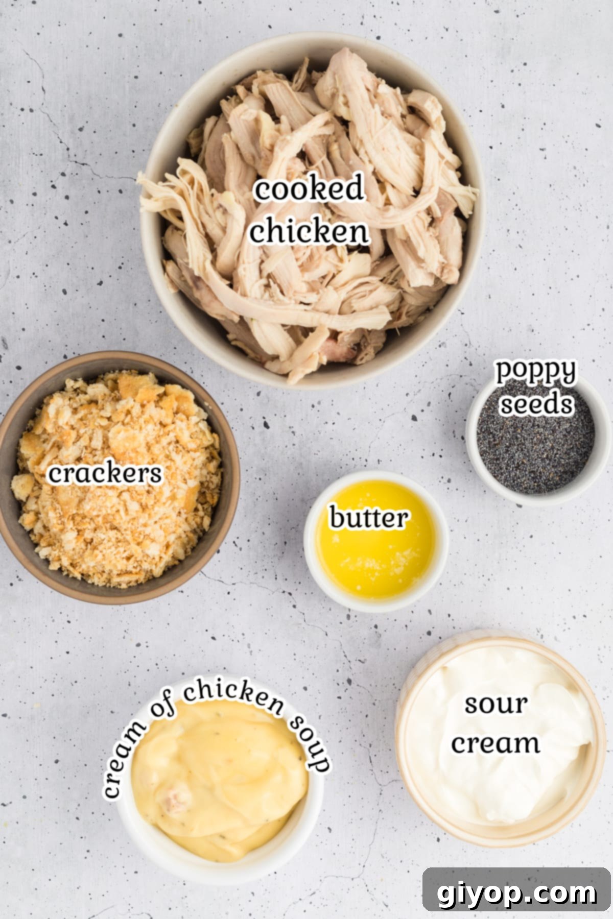 Ingredients arranged neatly on a counter, including chicken, soup cans, sour cream, crackers, and poppy seeds, ready for making the casserole.