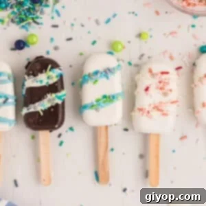 Cakesicles on a white surface with sprinkles scattered on it.