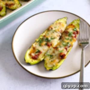 Savory Ground Beef Zucchini Boats 2 Two perfectly baked zucchini boats served on a pristine dinner plate, highlighting the melted cheese and savory ground beef filling.
