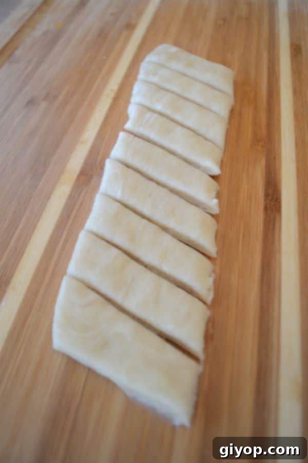 A wooden cutting board, with pieces of dough