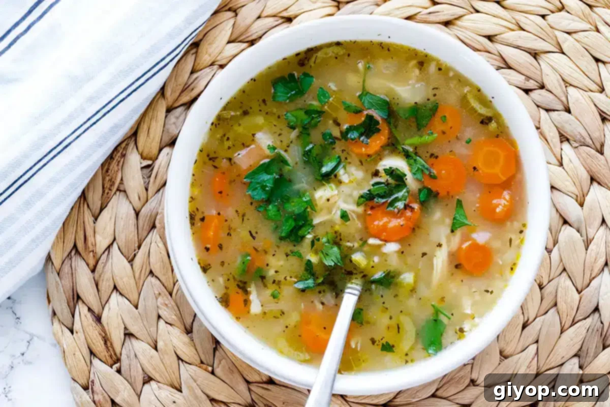 Hearty Instant Pot Chicken and Rice Soup 6 A top view of a white bowl with chicken rice soup.