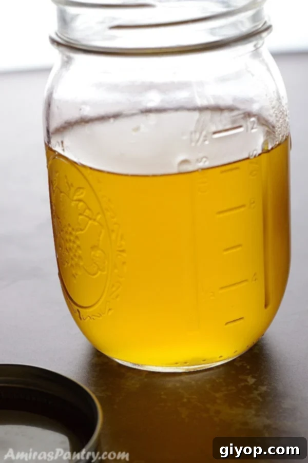 Crafting Golden Ghee from Butter 2 A mason jar with melted clear ghee in it.