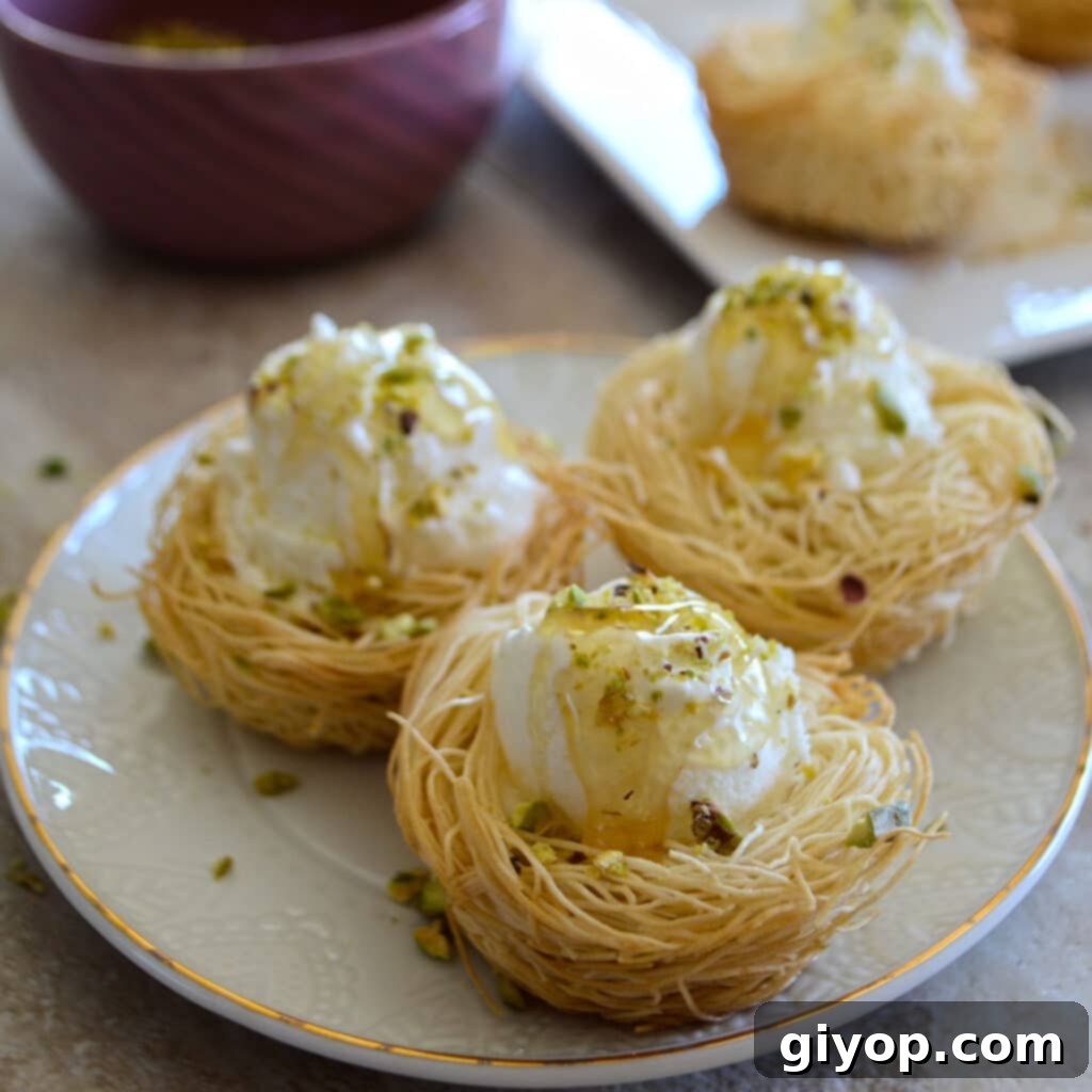 Individual Kunafa cups generously filled with ice cream, garnished with ground pistachios.