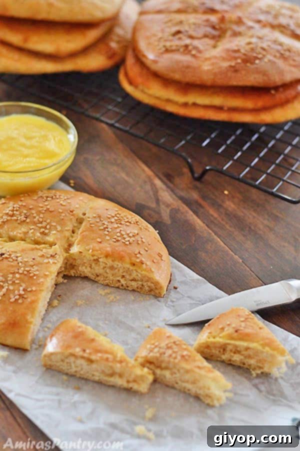 A freshly baked Khobz, Moroccan bread, cut into inviting slices on a wooden table, with a knife ready for serving.