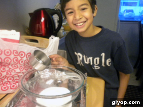 An old photograph showing a young child engaged in the process of making almond brittle, stirring the mixture carefully.