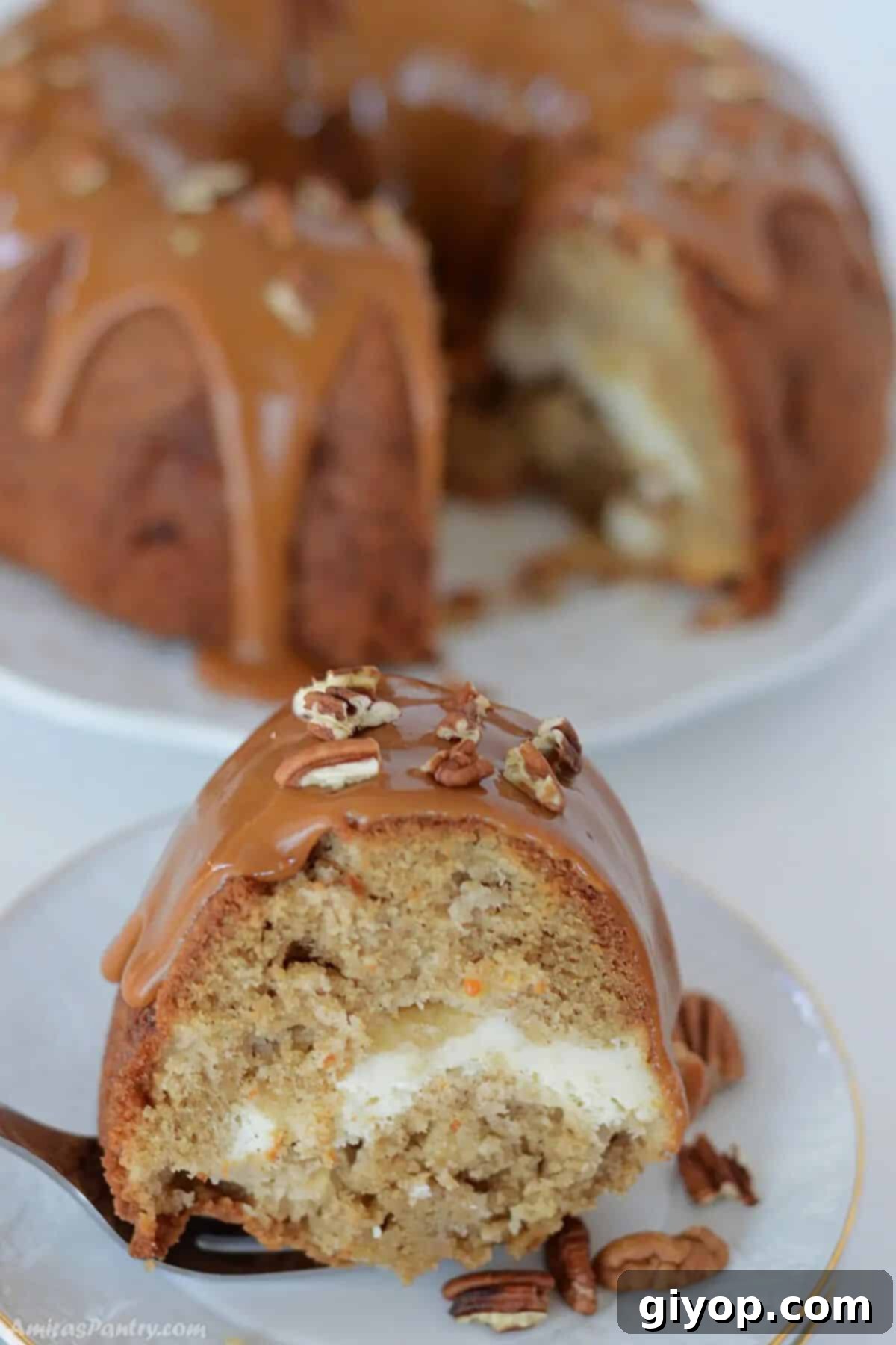 A beautifully presented slice of Apple Cream Cheese Bundt Cake on a white plate, showcasing its moist texture and creamy swirl.