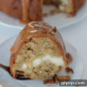 A close-up look at a slice of apple bundt cake, showcasing its texture and the cream cheese swirl.