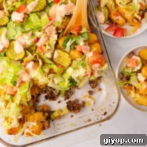Big mac casserole with a wooden spoon, ready to be served.