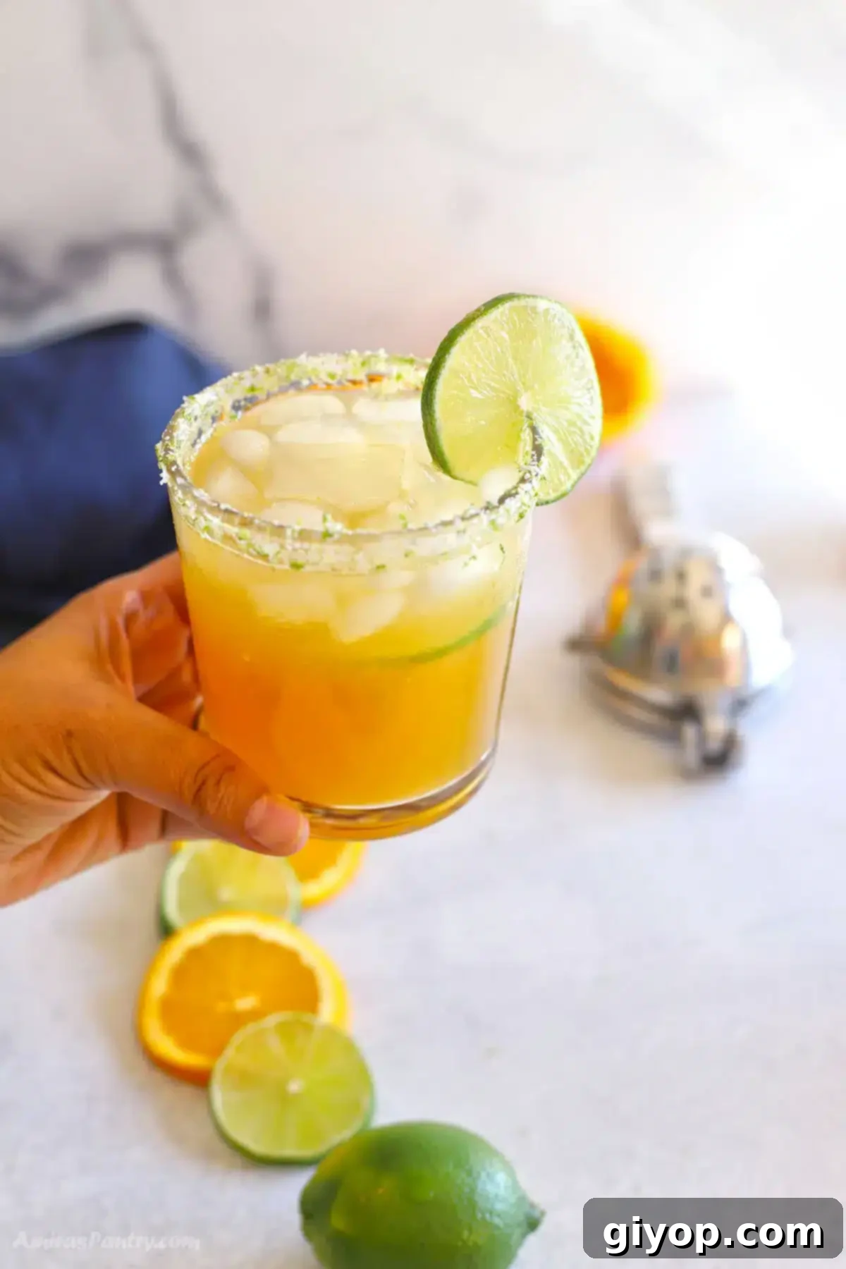 Virgin margarita mocktail served in a glass with lime and orange slices.