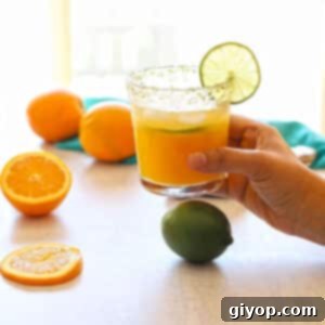 A hand holding a glass or virgin margarita.